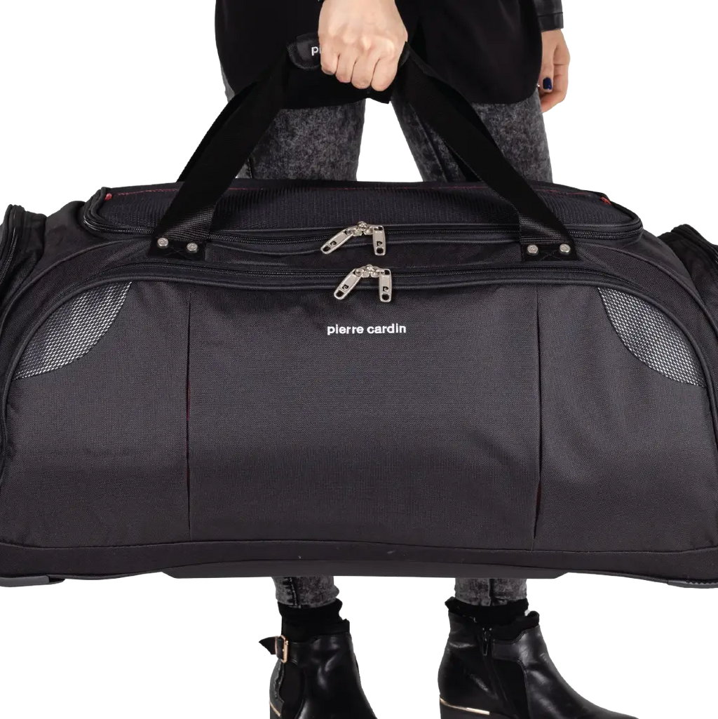 Person holding a black duffel bag with 'Pierre Cardin' branding on a white background