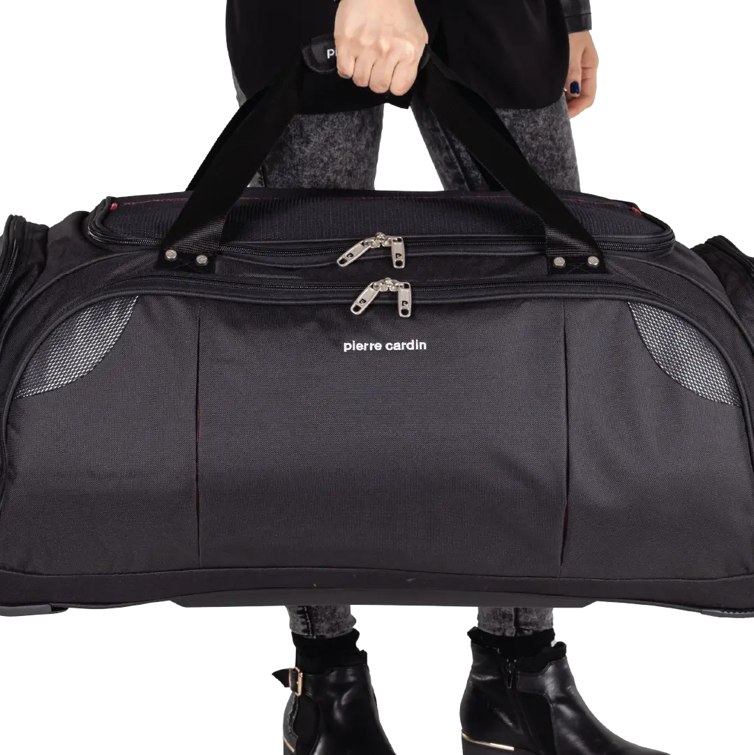 Person holding a black duffel bag with 'Pierre Cardin' branding on a white background
