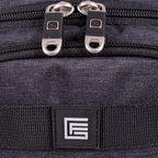 Close-up of a dark gray textured fabric bag with dual silver zipper pulls and a black rectangular logo patch featuring a white stylized 'E' on a webbing strap.