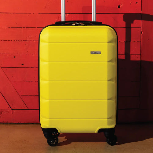 Yellow suitcase with a brand logo against a red wooden background