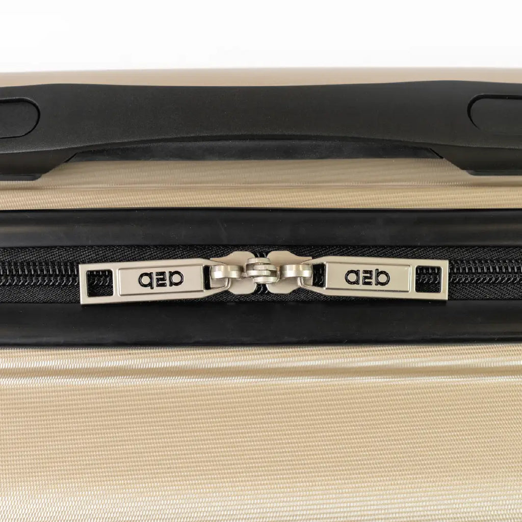Close-up of a beige suitcase with a black handle and visible brand logo.