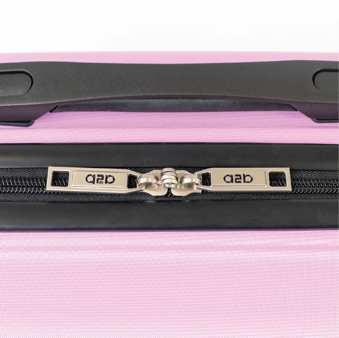 Close-up of a pink suitcase with a black handle and zipper, featuring the brand.
