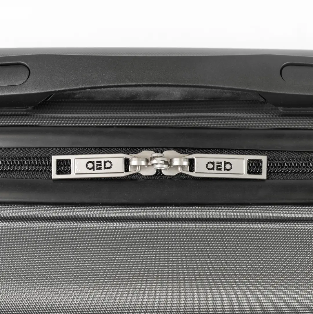 Close-up of a gray suitcase with a zipper and 'QED' branding.