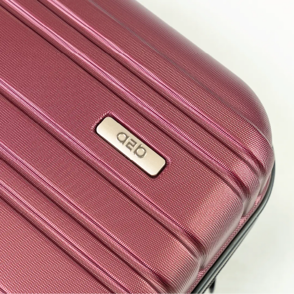 Close-up of a red suitcase with a brand logo on a white background
