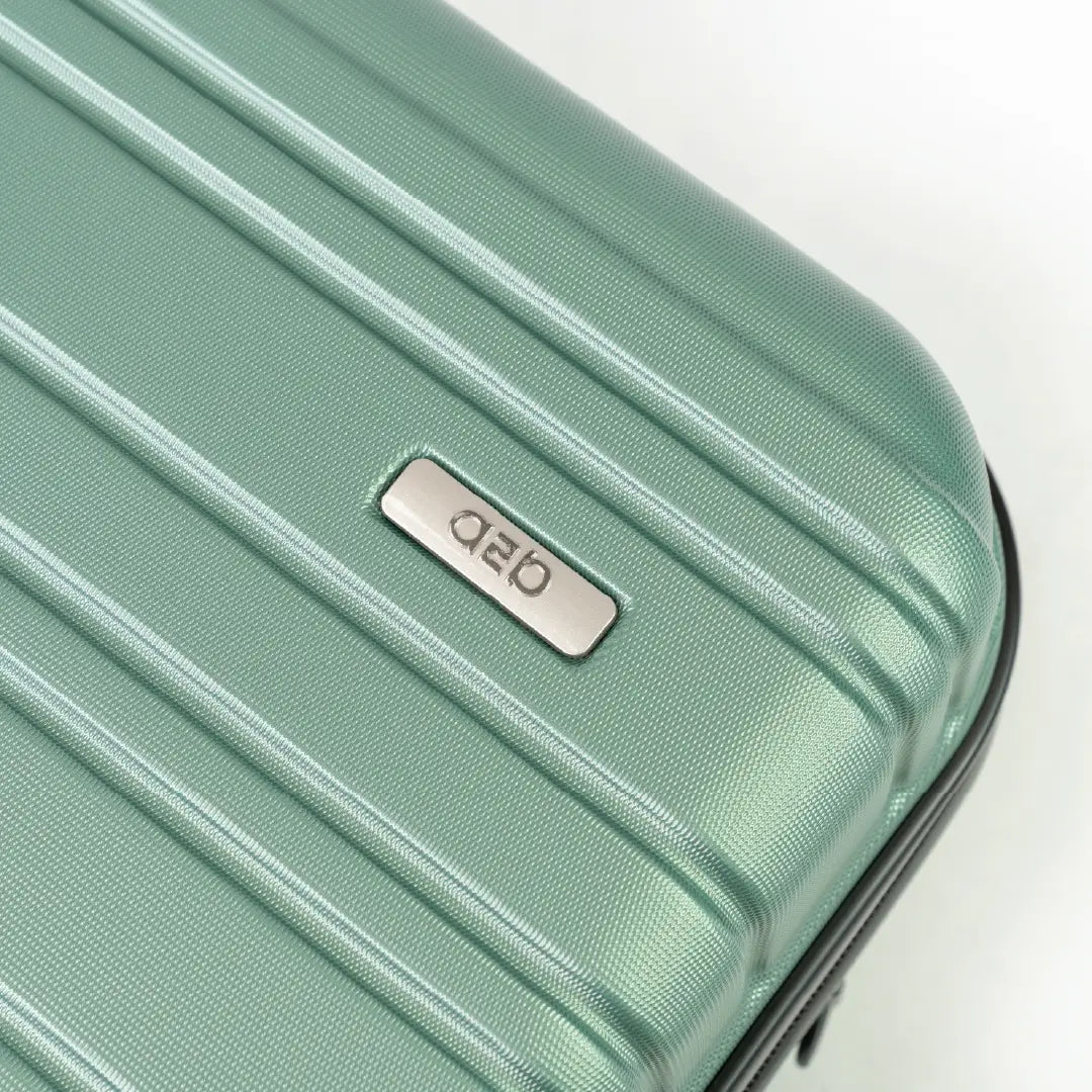 Mint green suitcase with a brand logo on a light gray background