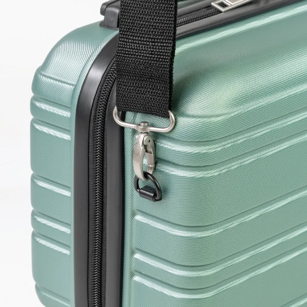 Close-up of a green suitcase with a black handle strap and zipper.