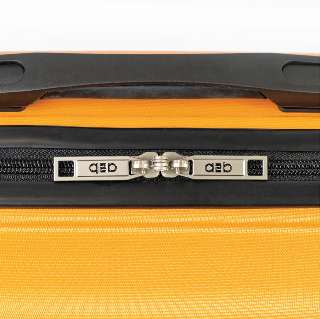 Close-up of a yellow suitcase with a black handle and zipper, featuring the brand.