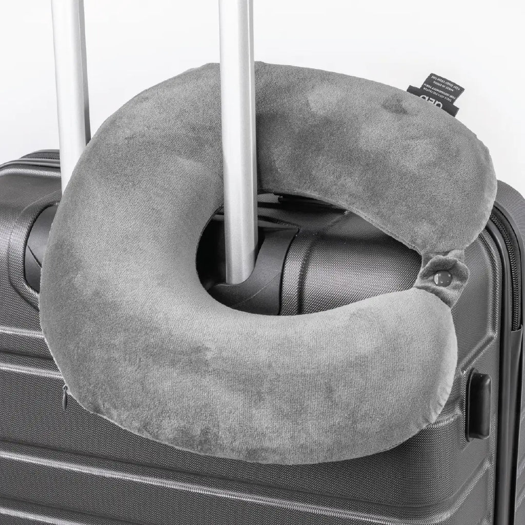 Gray travel neck pillow attached to a suitcase handle