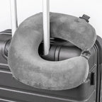 Gray travel neck pillow attached to a suitcase handle