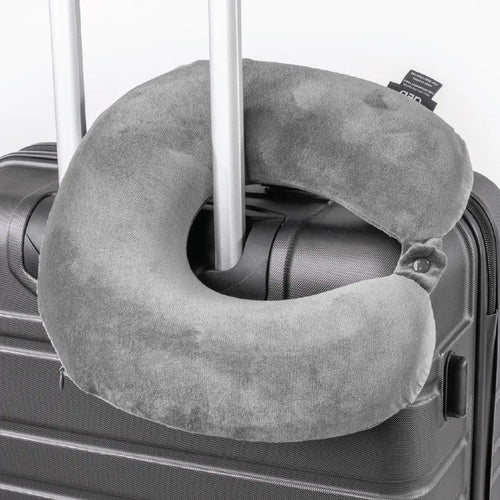 Gray travel neck pillow attached to a suitcase handle