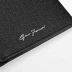 Close-up of a black leather wallet with brand logo