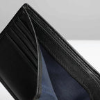 Close-up of a black leather wallet with blue lining on a light gray background