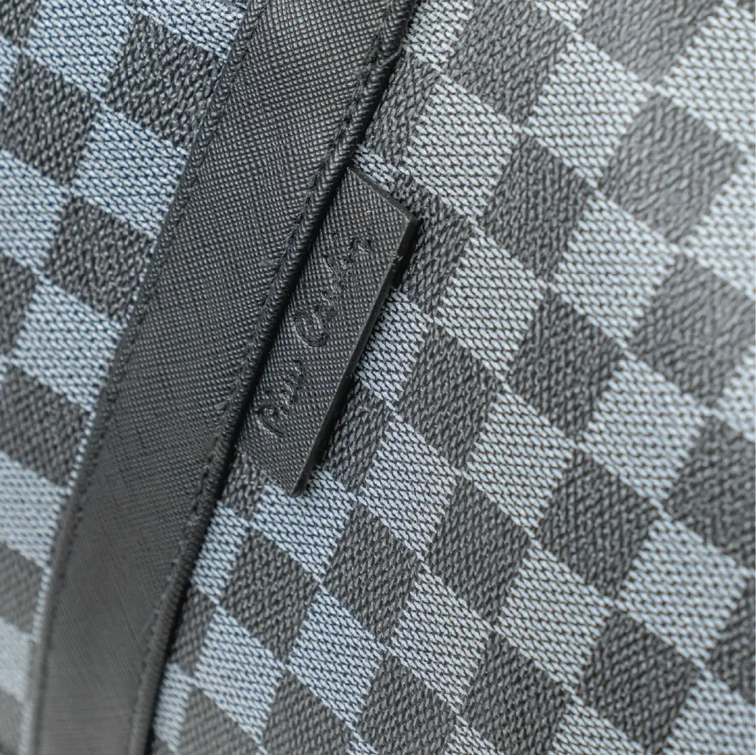 Close-up of a textured gray fabric with a brand logo.