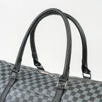 Checkered duffel bag with black handles on a light gray background