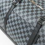 Checkered duffel bag with black straps on a white background