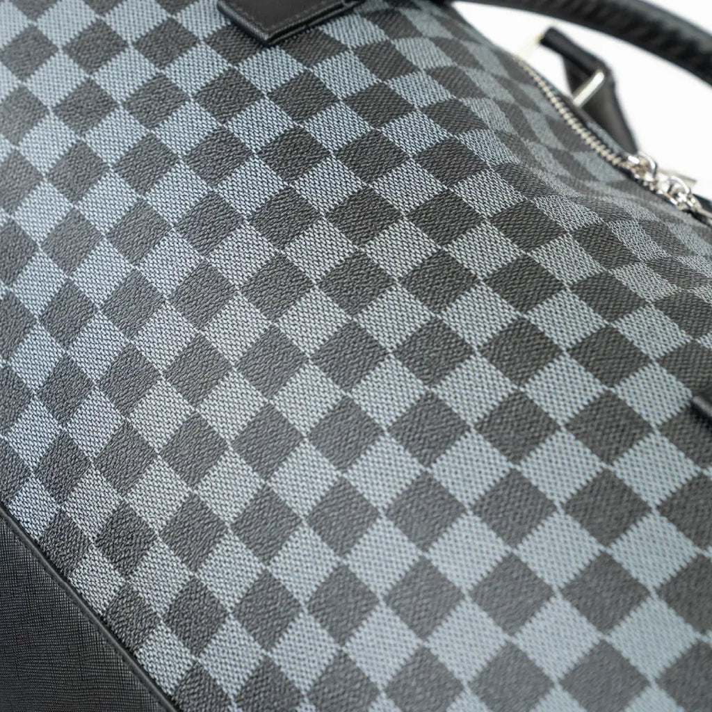 Close-up of a gray and black checkered bag with a blurred background