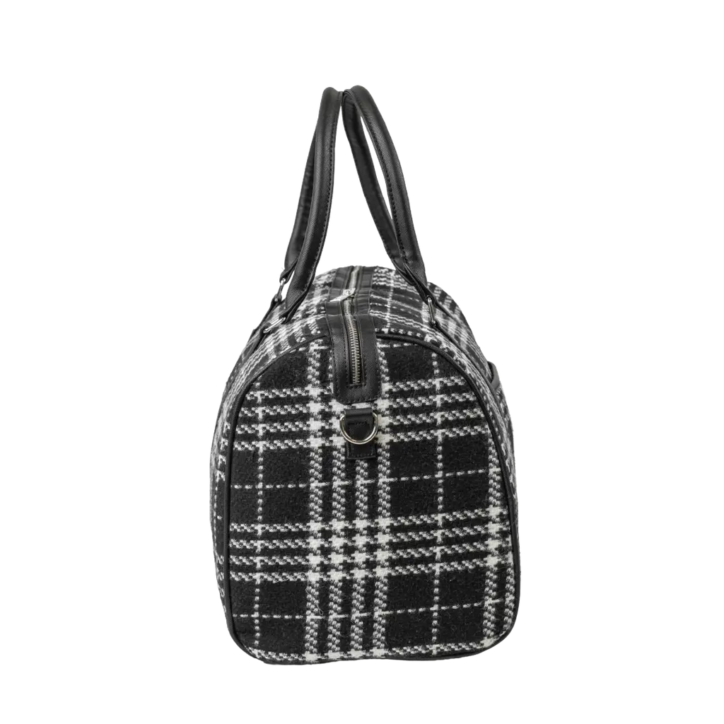 Black and white checkered handbag with leather handles on a white background