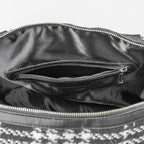Close-up of a black leather handbag with a zipper, showing the interior.