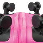 Close-up of a pink suitcase with black wheels on a white background