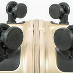 Close-up of a beige suitcase with black wheels on a white background
