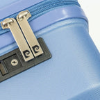 Close-up of a blue suitcase with a gold zipper pull and black lock.