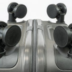 Close-up of a silver suitcase with black wheels on a white background