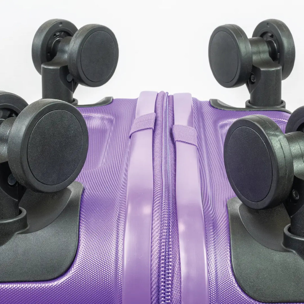 Close-up of a purple suitcase with black wheels on a white background