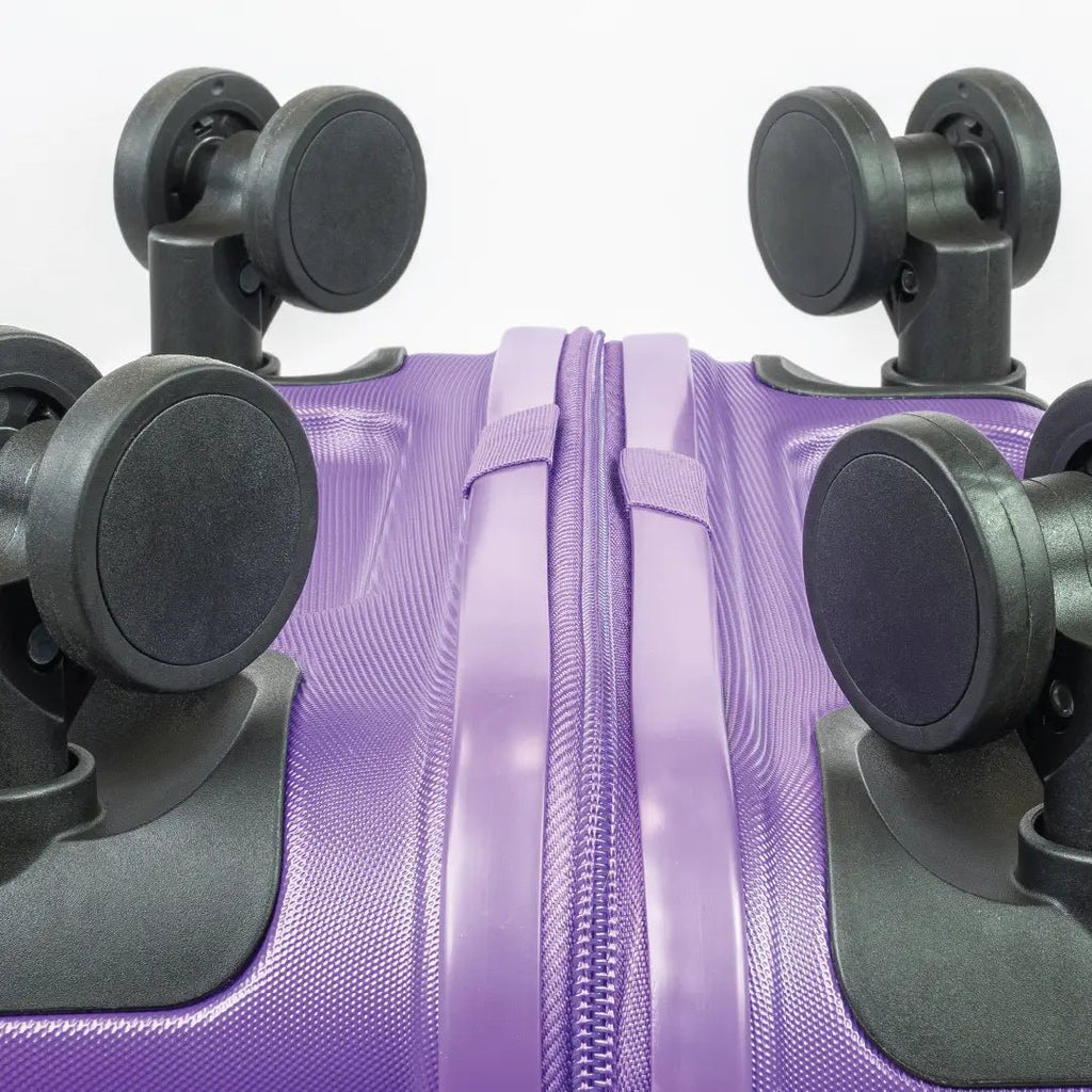 Close-up of a purple suitcase with black wheels on a white background