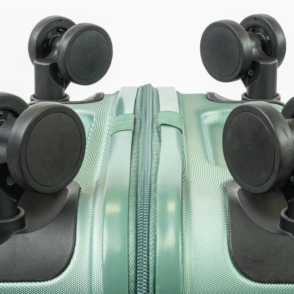 Close-up of a green suitcase with black wheels on a white background