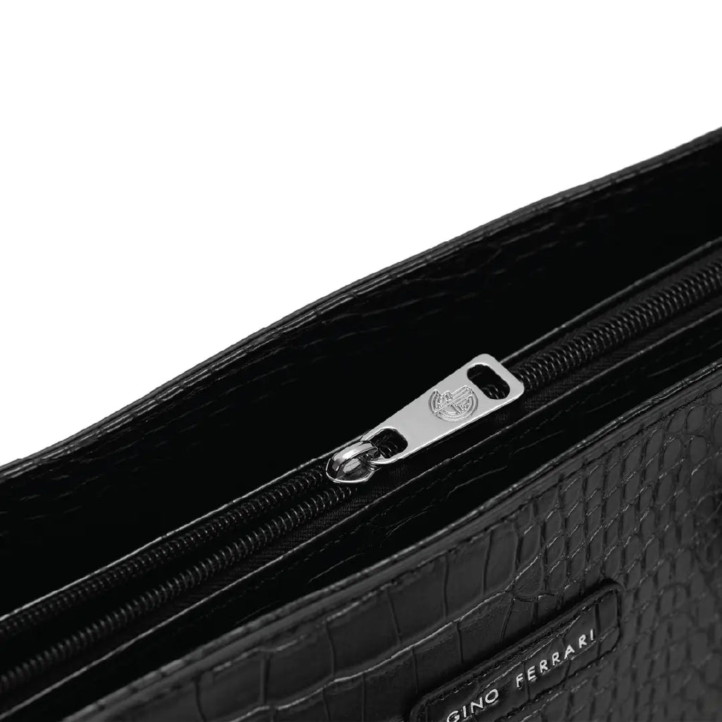 Close-up of a black textured clutch bag with a zipper and 'Gino Ferrari' branding.