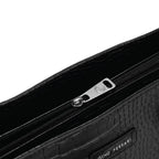 Close-up of a black textured clutch bag with a zipper and 'Gino Ferrari' branding.