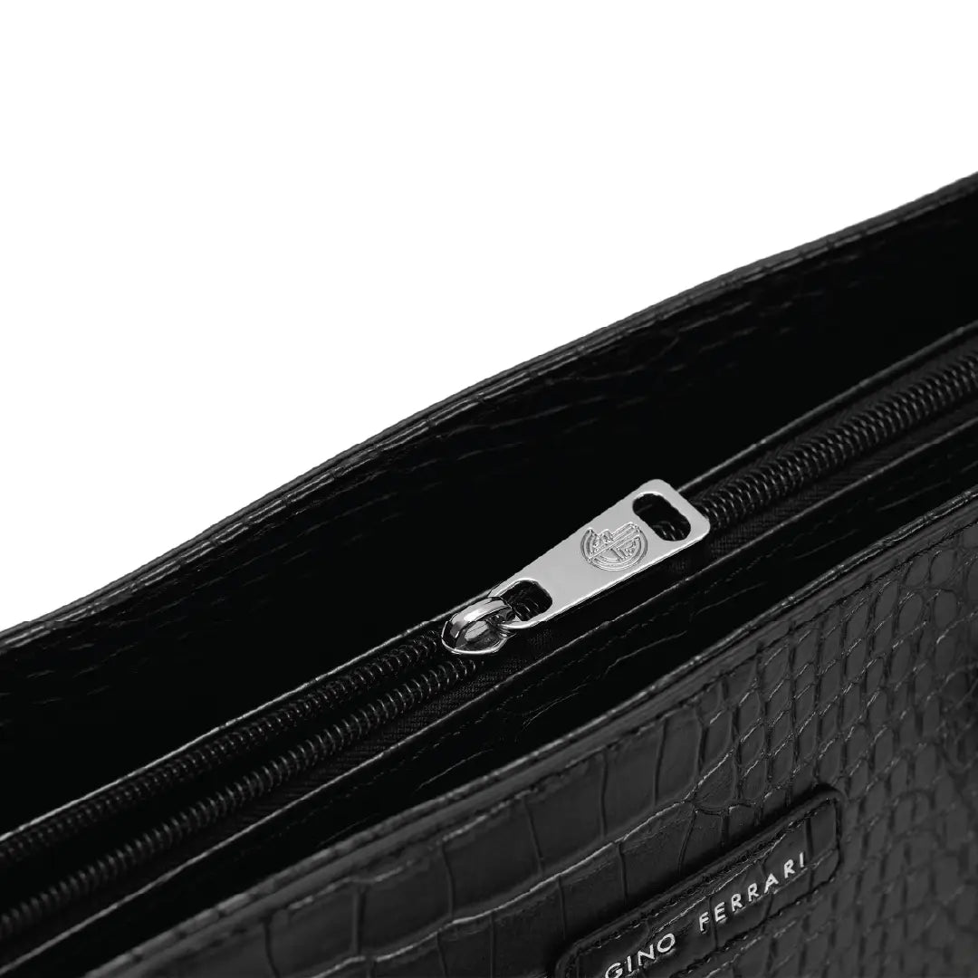 Close-up of a black textured clutch bag with a zipper and 'Gino Ferrari' branding.