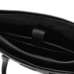 Close-up of a black leather bag with a strap on a white background