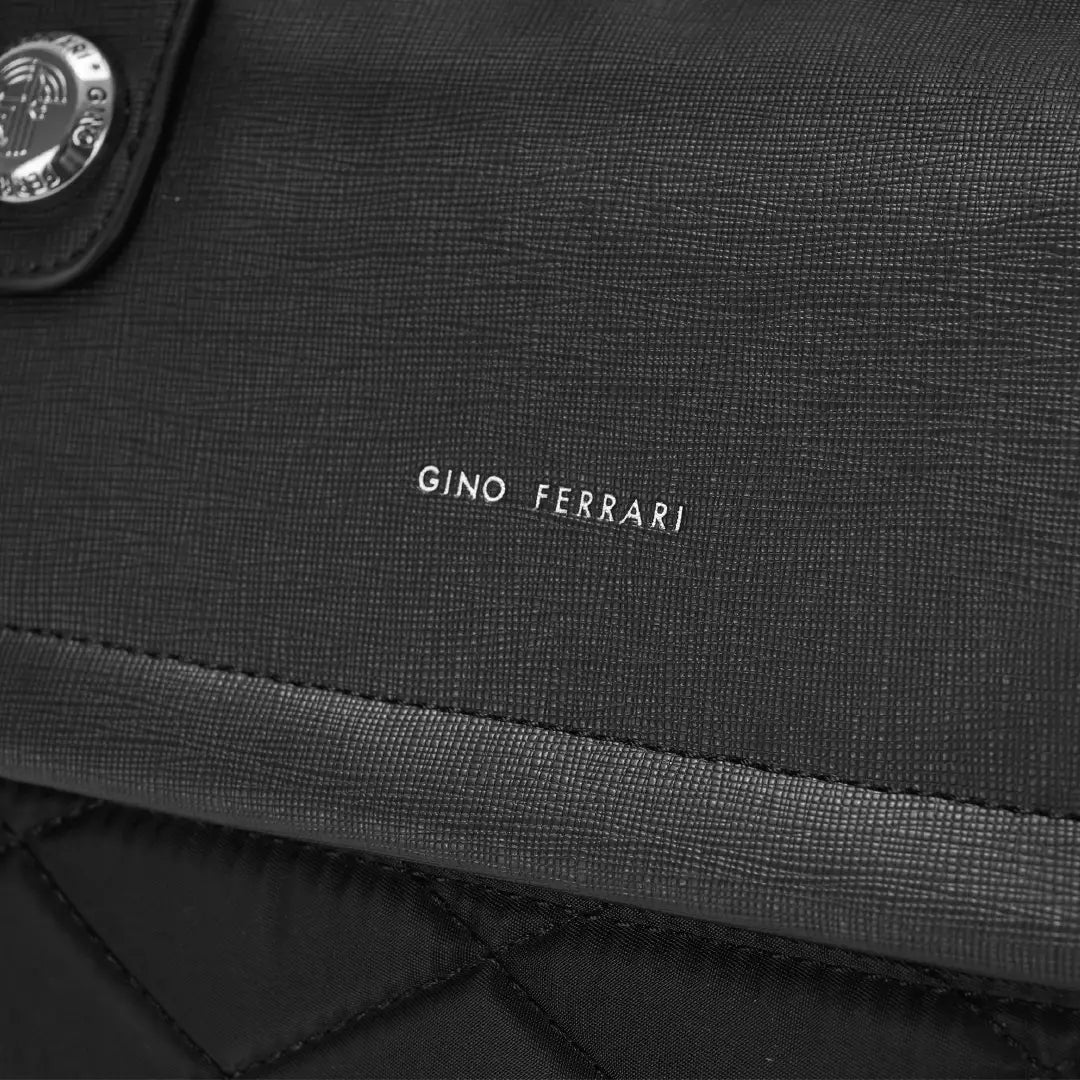 Close-up of a black textured fabric with 'Gino Ferrari' branding.