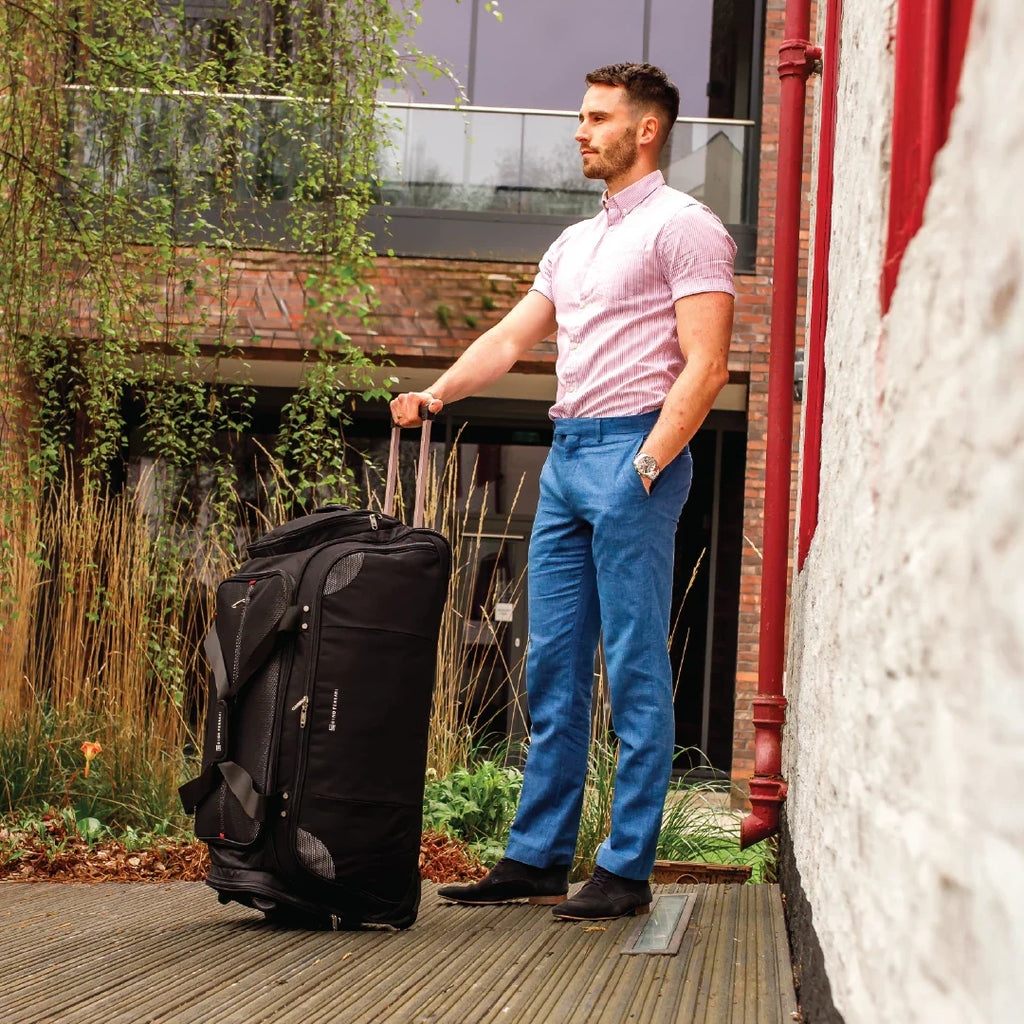 Man with a suitcase standing outside a building