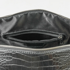 Leather-look textured bag with a pocket inside, handles and a silver zip with branding on it.