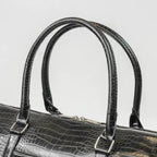 Leather-look textured bag with handles and a silver zip with branding on it.