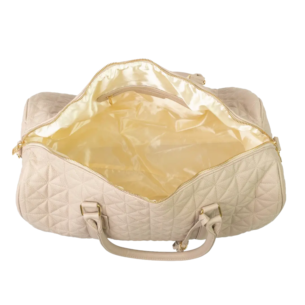 A close-up of a beige bag with cream interior, patterned stitching and a gold zip.