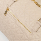 A close-up of a beige bag with patterned stitching, a gold zip and handles