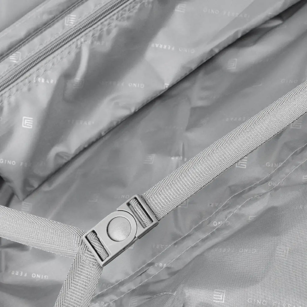 Close-up of the inside of a suitcase showing the straps and a buckle.