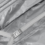 Close-up of the inside of a suitcase with a strap and visible branding.