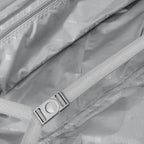 Close-up of a gray bag with a strap and visible branding.