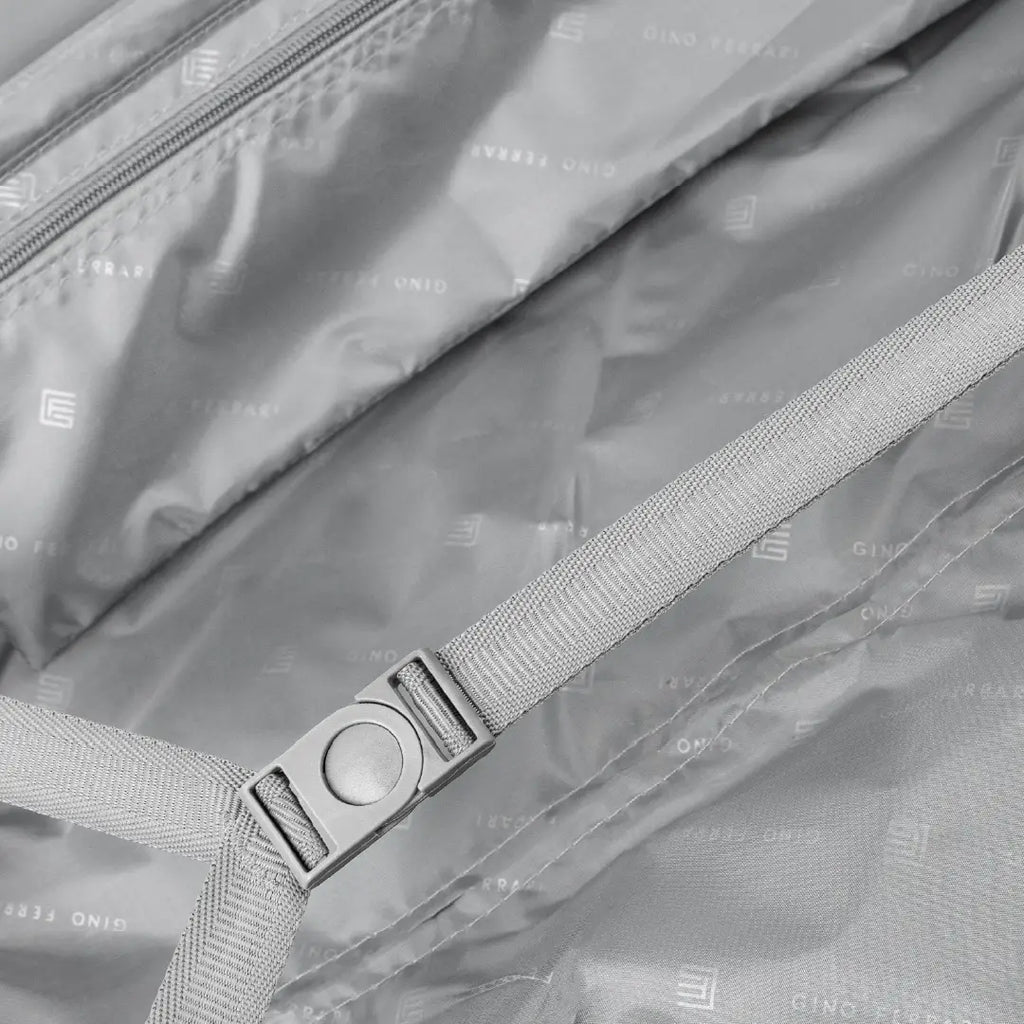Close-up of a suitcase with a strap for holding luggage securely.