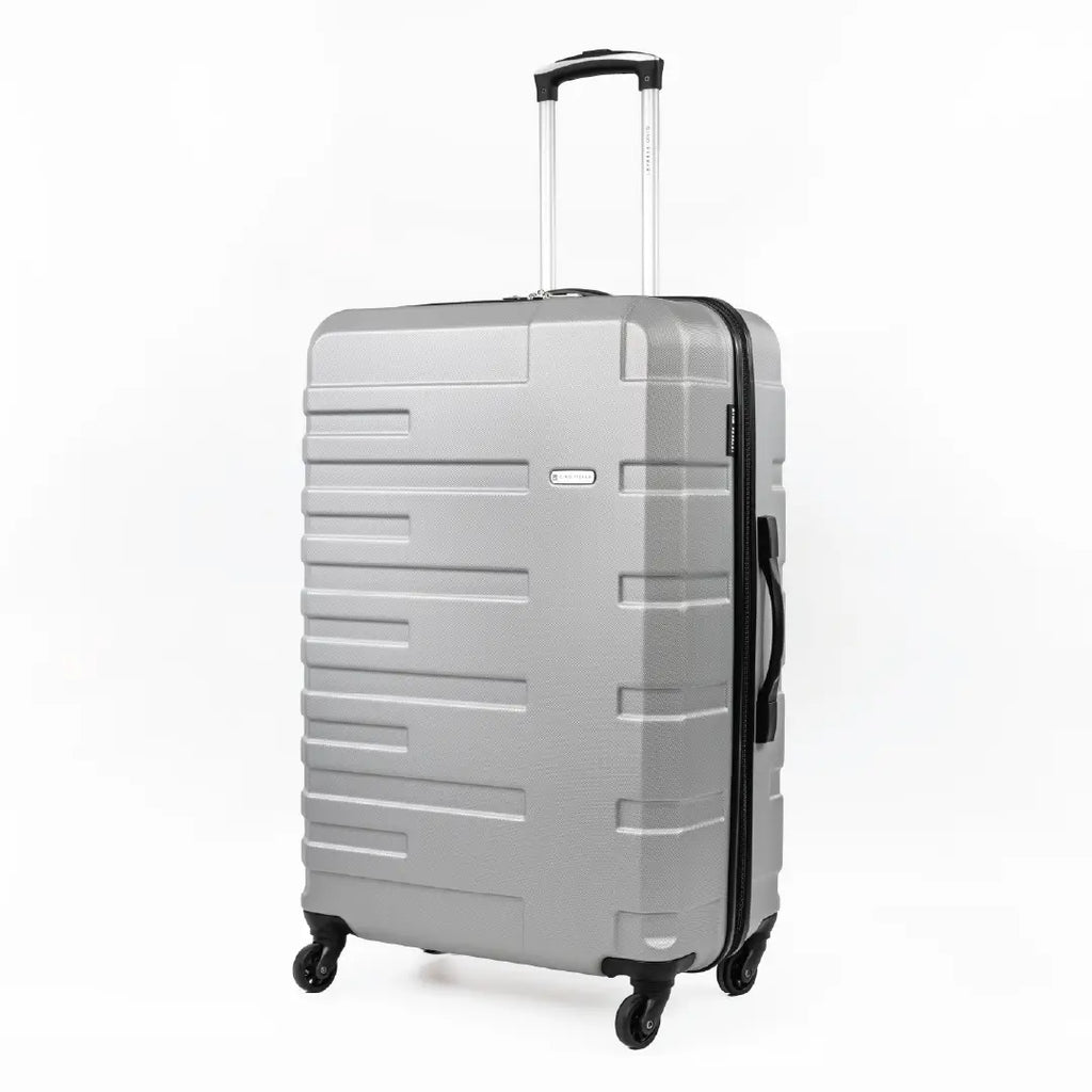 Silver suitcase with black wheels and handle on a white background