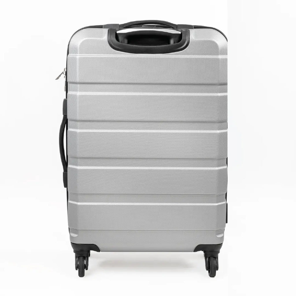 Silver suitcase with black handle and wheels on a white background