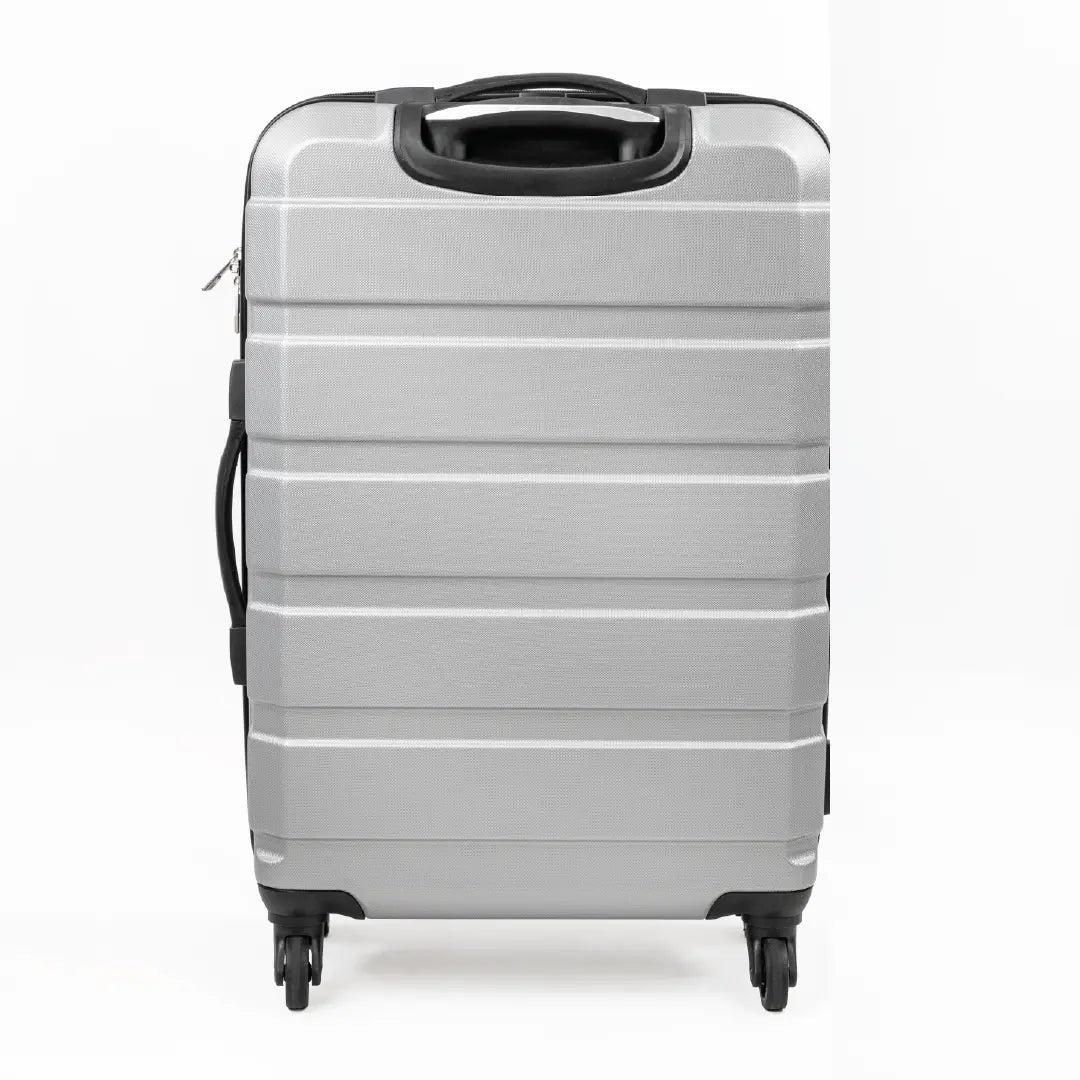 Silver suitcase with black handle and wheels on a white background