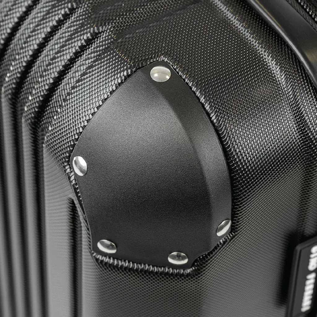 Close-up of a black suitcase with a textured surface and visible brand name.