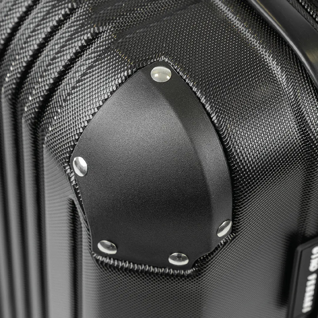 Close-up of a black suitcase with a textured surface and visible brand name.
