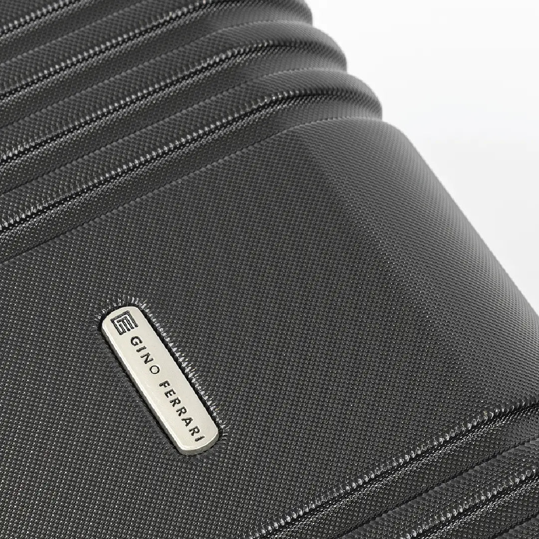 Close-up of a black suitcase with a visible brand logo on a white background