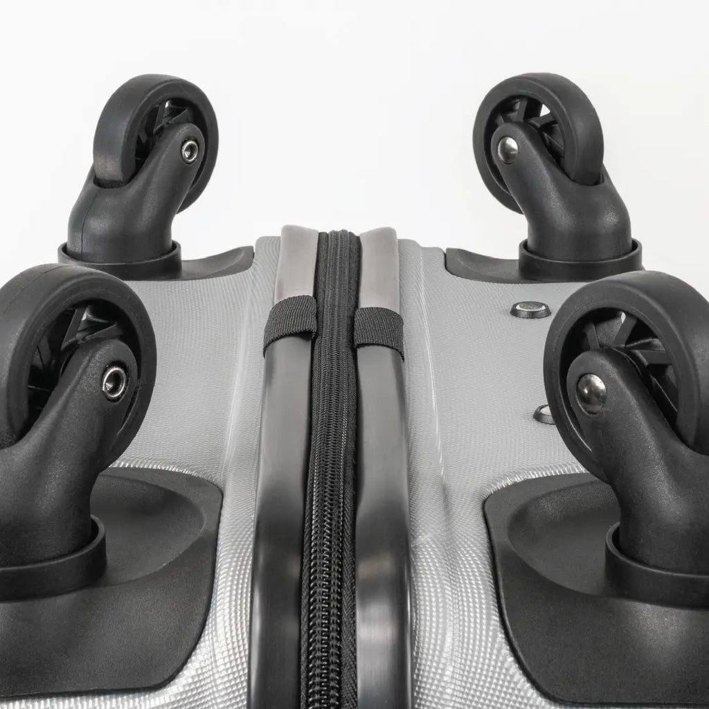 Close-up of the bottom of a silver suitcase showcasing the wheels and zip.